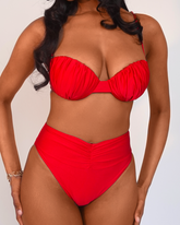 Model in high waisted swimwear bottoms in cherry red